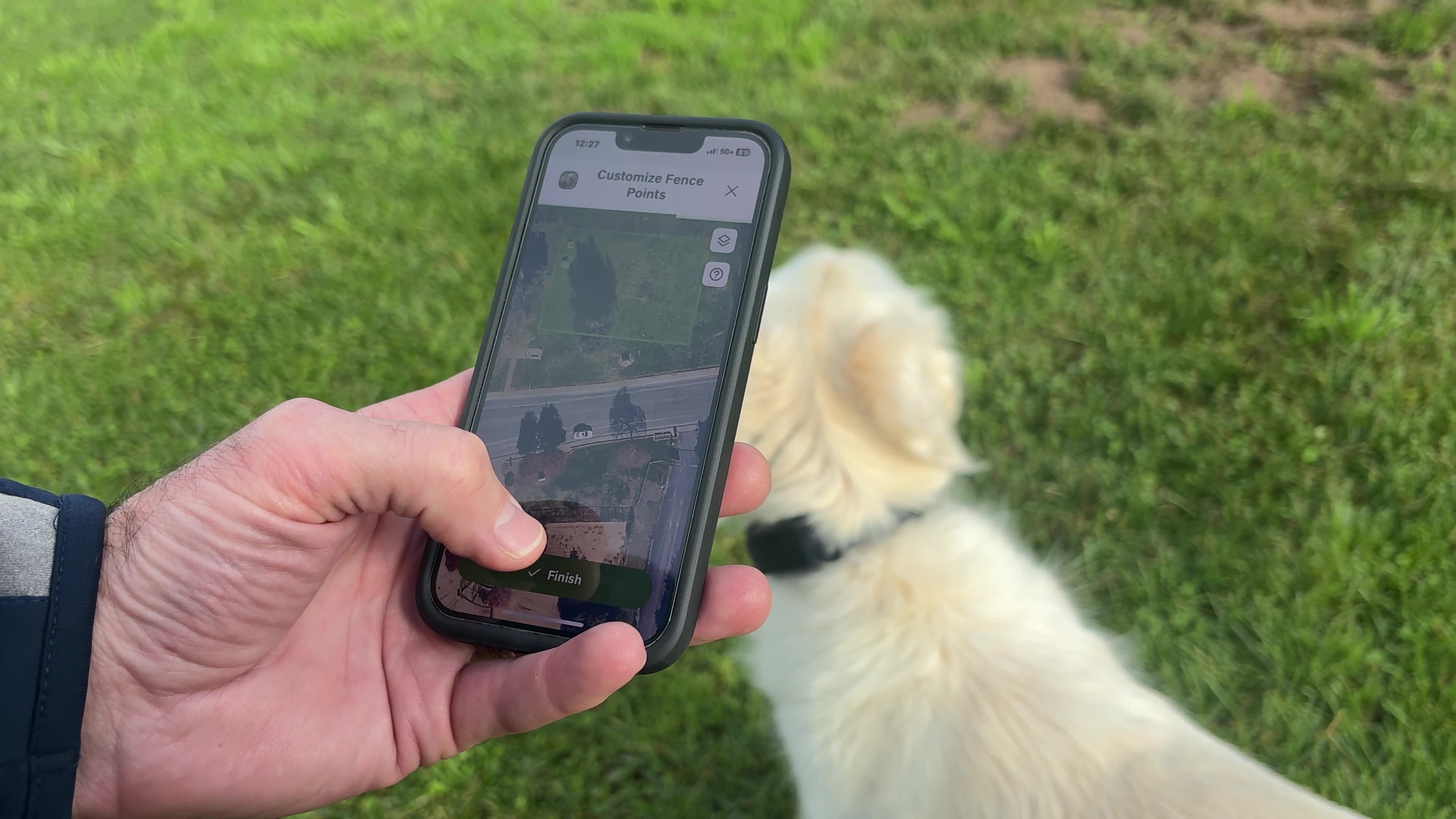 Setting up SpotOn NOVA GPS fence boundary on phone while Kona explores the yard
