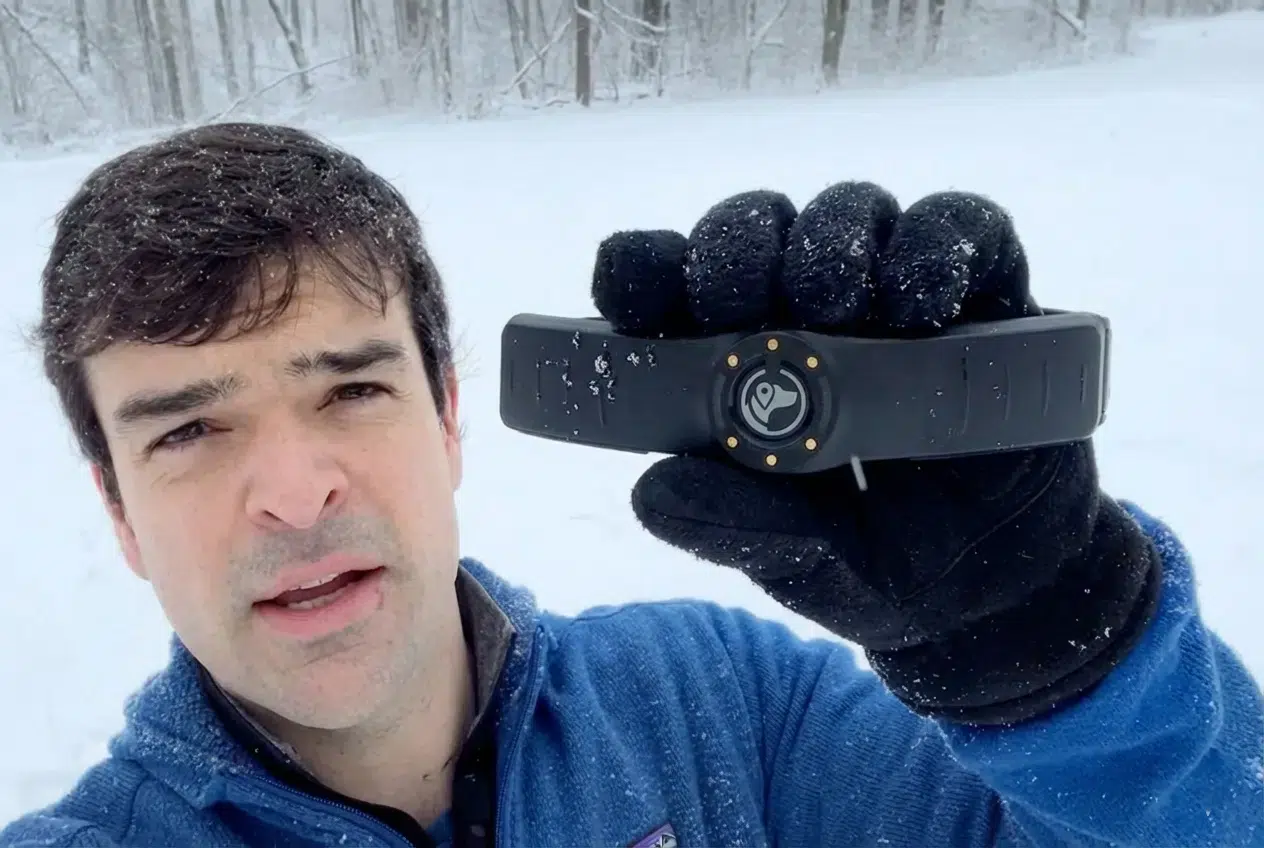 Zach holding SpotOn collar in snow storm.